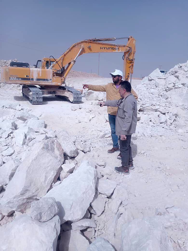 مهندسون يشرفون على عملية استخراج بحفارة ثقيلة في مقلع رخام مفتوح